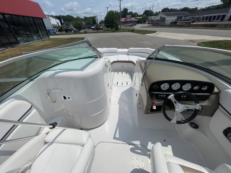 View of the boat's interior with white seating and dashboard.