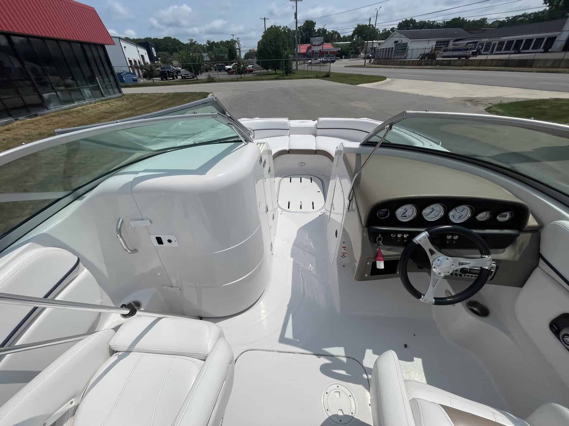 View of the boat's interior with white seating and dashboard.