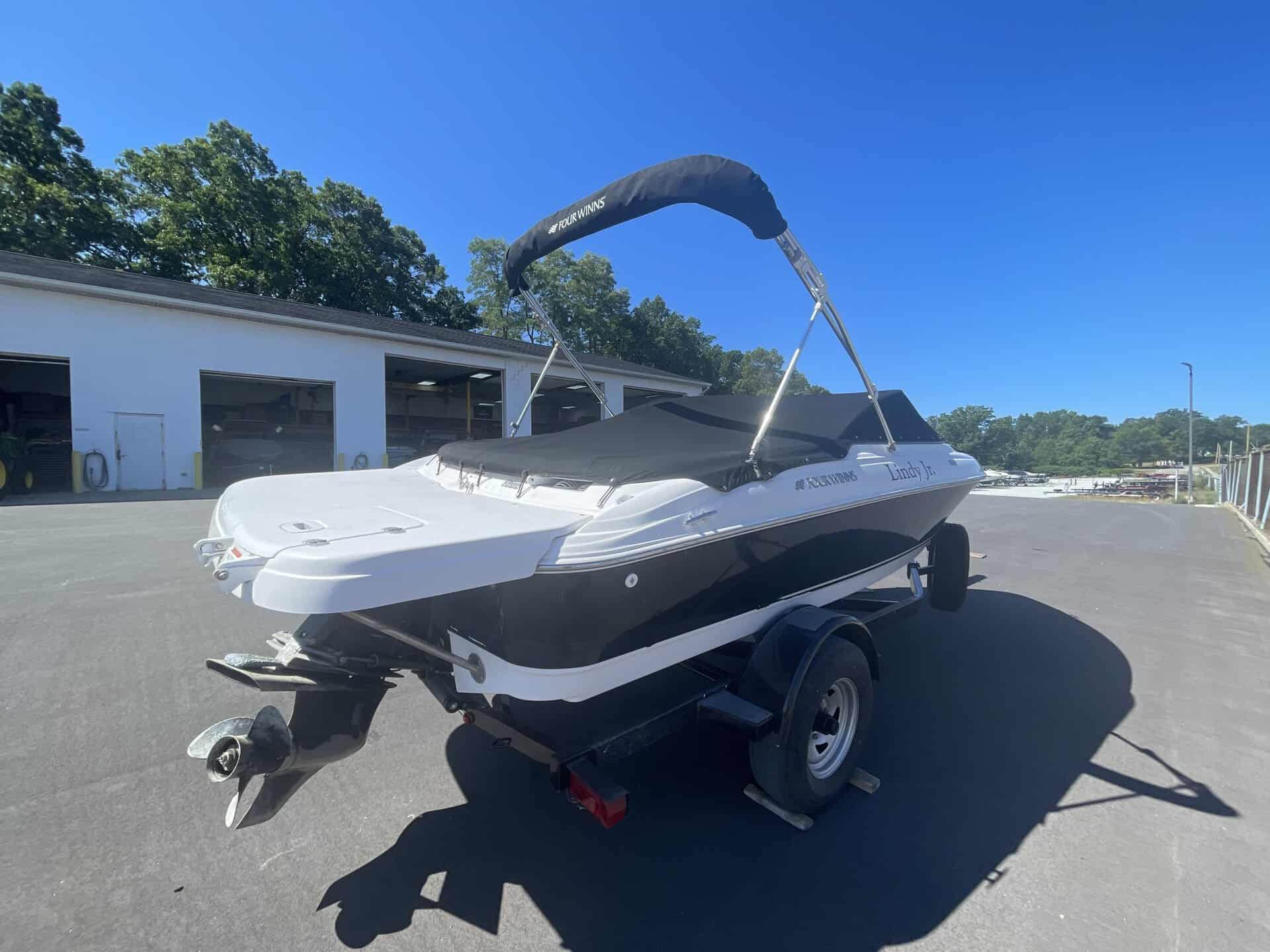 White and black 2011 Four Winns 180H boat on trailer at Hall's Sport Center.