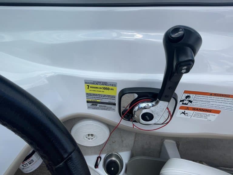 Boat control panel with gear shift and warning labels at Hall's Sport Center.