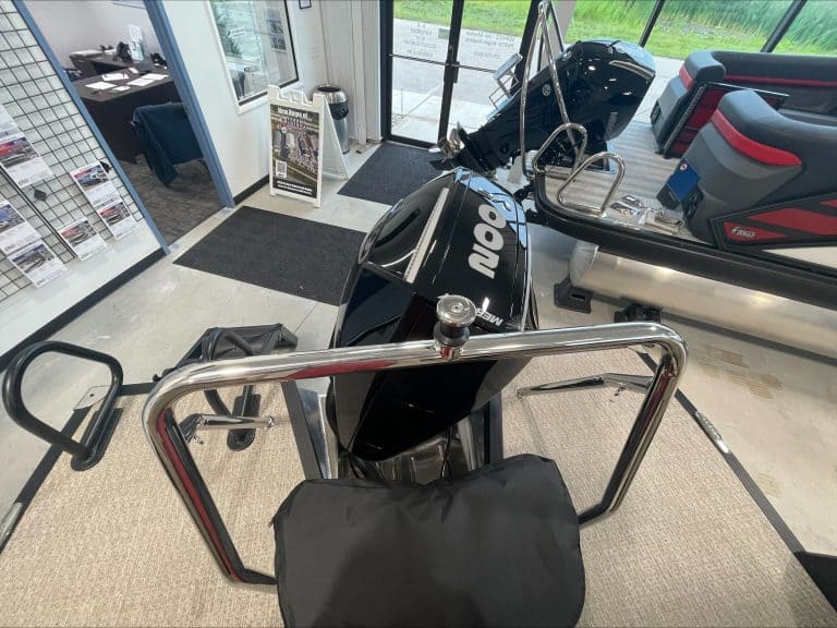 Boat motor on display at Hall's Sport Center with fitness equipment nearby.