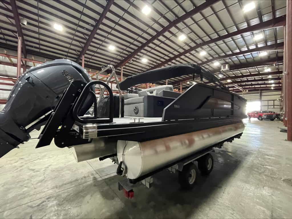 Luxury pontoon boat at Hall's Sport Center with outboard motor and spacious deck.