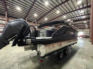 Luxury pontoon boat at Hall's Sport Center with outboard motor and spacious deck.