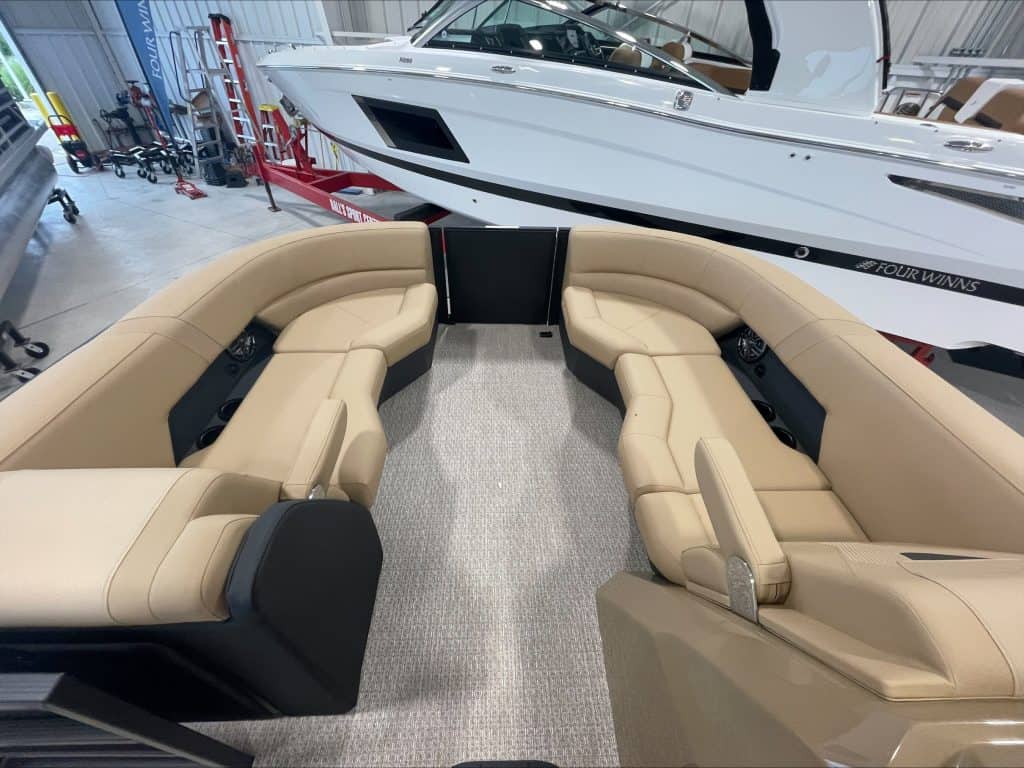 Comfortable beige boat seating area with a yacht in the background.