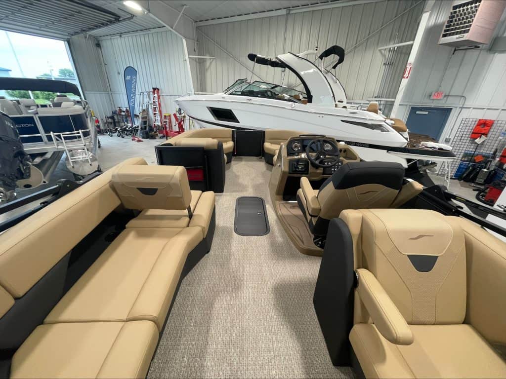Luxury pontoon boat with beige seating inside Hall's Sport Center.