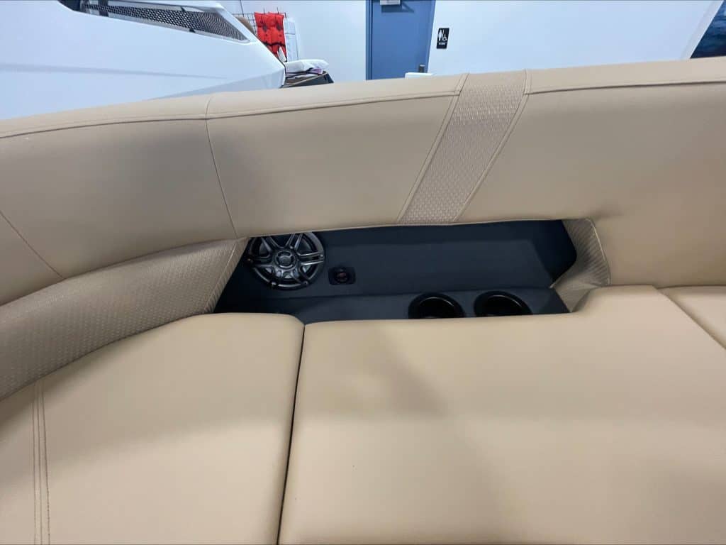 Close-up of beige boat seating with storage compartments and cup holders.