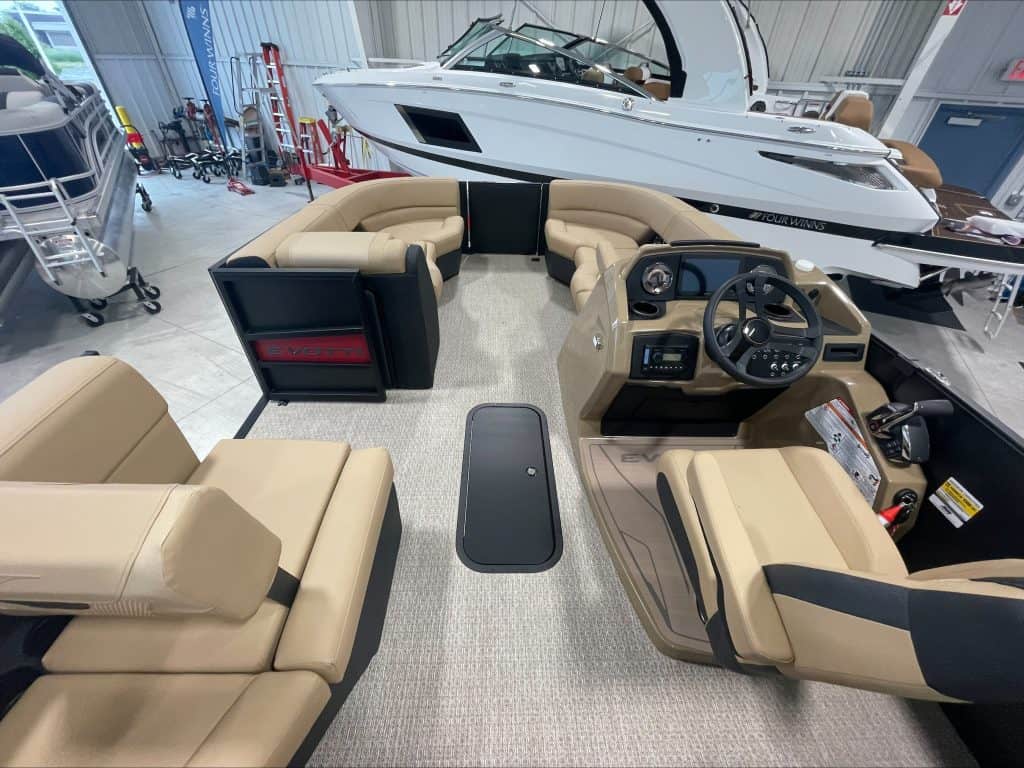 Elegant pontoon boat cockpit with beige seating and steering wheel at Hall's Sport Center.