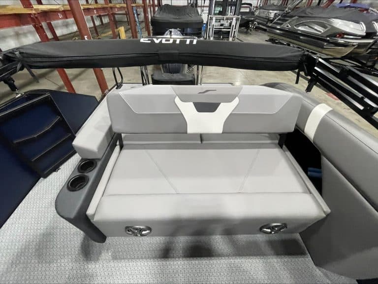 Comfortable gray pontoon boat seat with cup holders and safety rail.