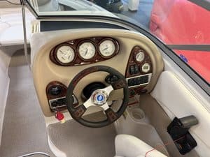 Boat dashboard with gauges and steering wheel in a 2006 Four Winns 230.