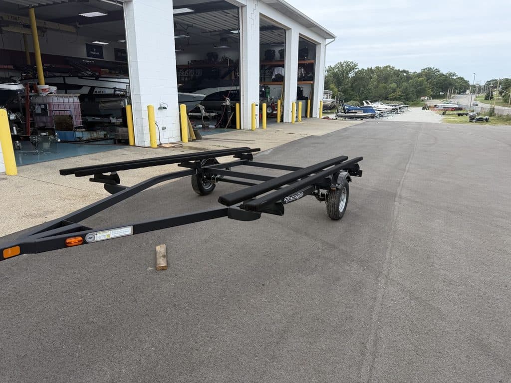 Boat trailer parked outside Hall's Sport Center with boats inside.