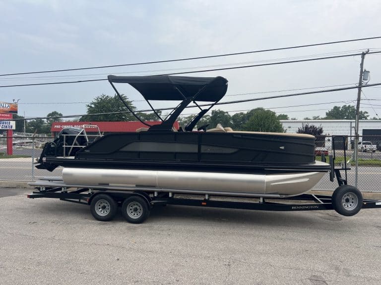 Luxury pontoon boat on trailer at Hall's Sport Center with canopy and seating.