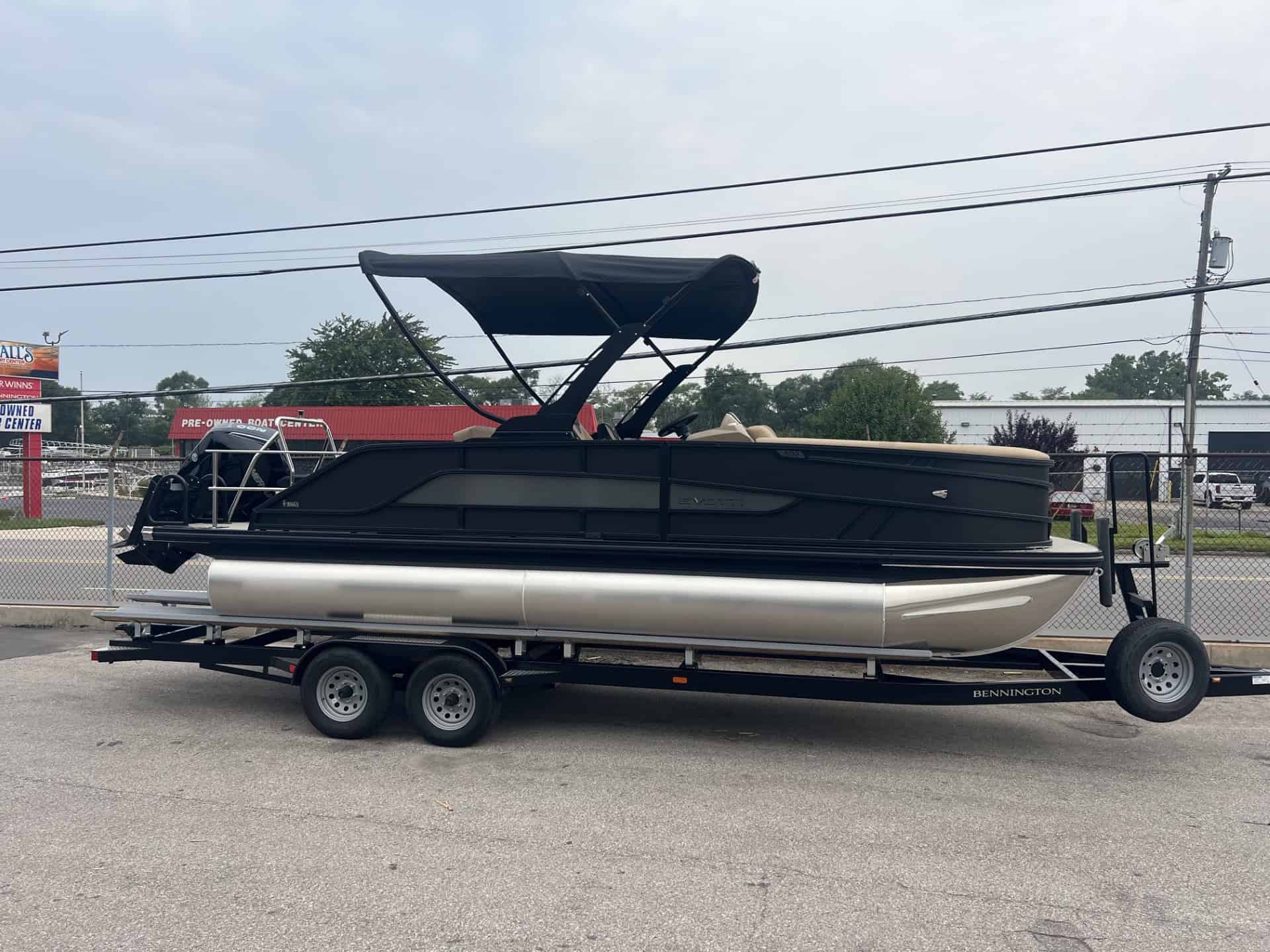 Luxury pontoon boat on trailer at Hall's Sport Center with canopy and seating.