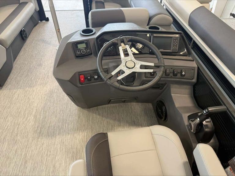 Boat dashboard with steering wheel and control panel at Hall's Sport Center.