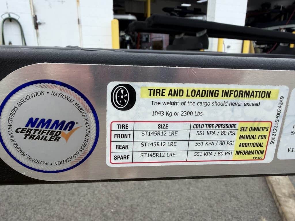 Tire and loading info label on trailer with NMMA certification.