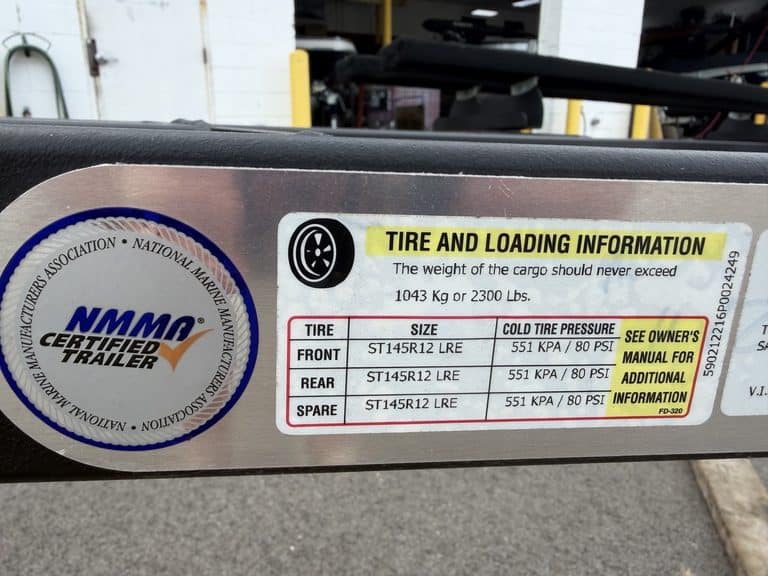 Tire and loading info label on trailer with NMMA certification.