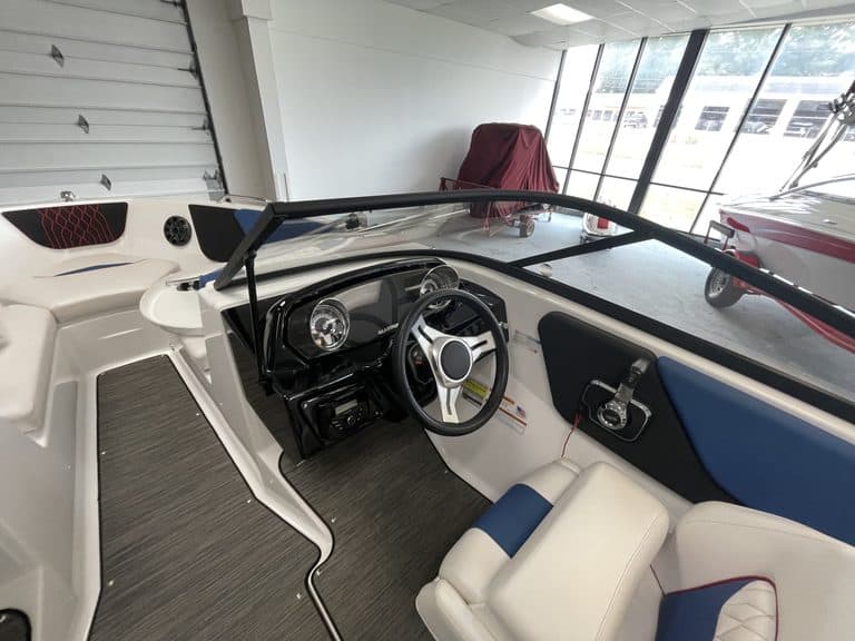 Close-up of the dashboard and steering wheel of a Glastron GX215 boat.