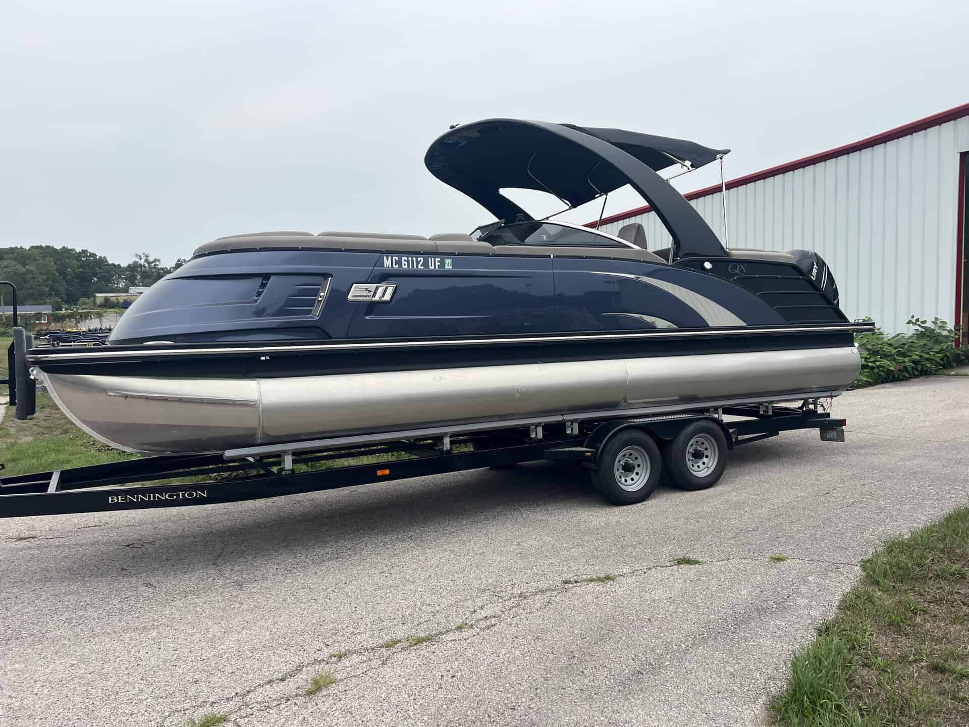 Luxury Bennington pontoon boat on trailer at Hall's Sport Center.