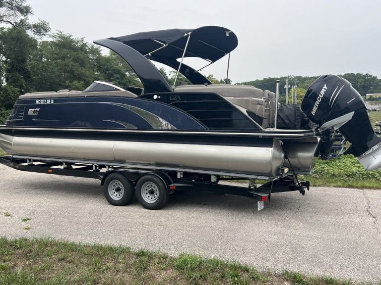 Bennington pontoon boat with Mercury outboard motor on trailer.