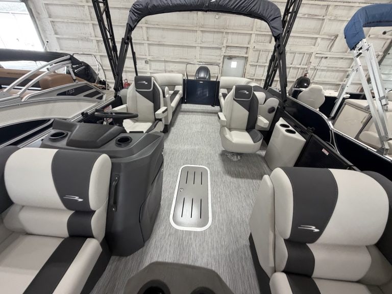 Interior view of a Bennington 22 S1SR pontoon boat with seating and steering area.