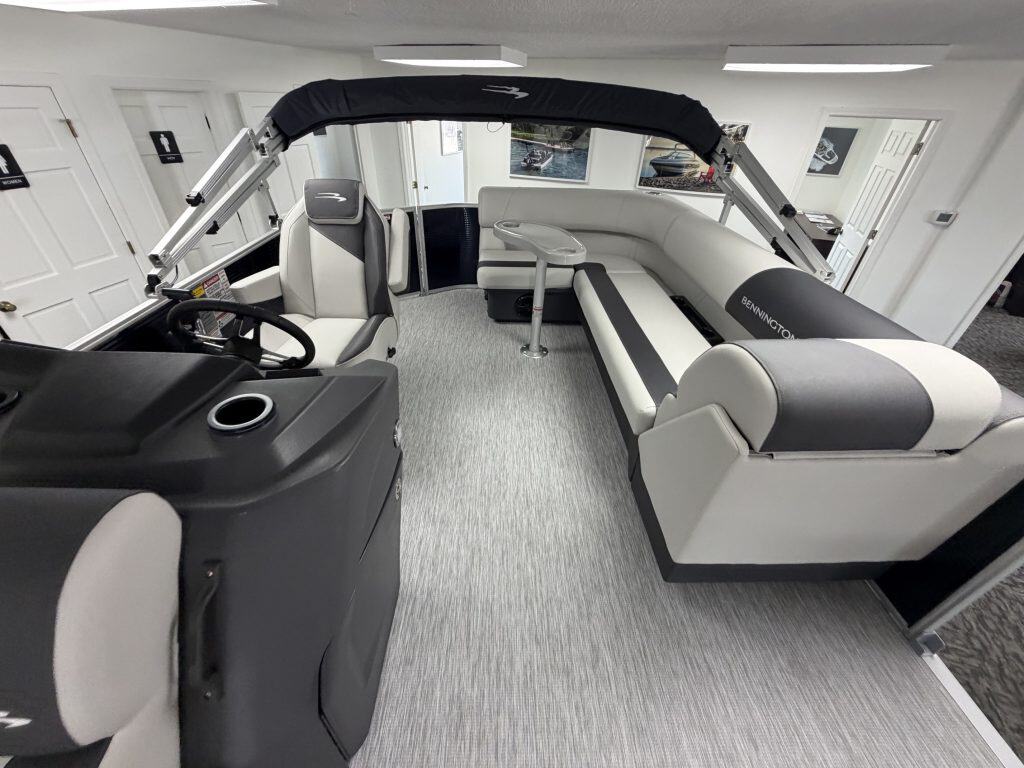 Interior view of a Bennington 20SL S1 pontoon boat with seating and steering area.
