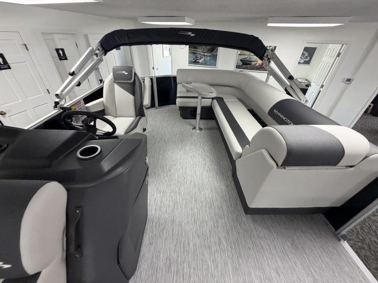 Interior view of a Bennington 20SL S1 pontoon boat with seating and steering area.