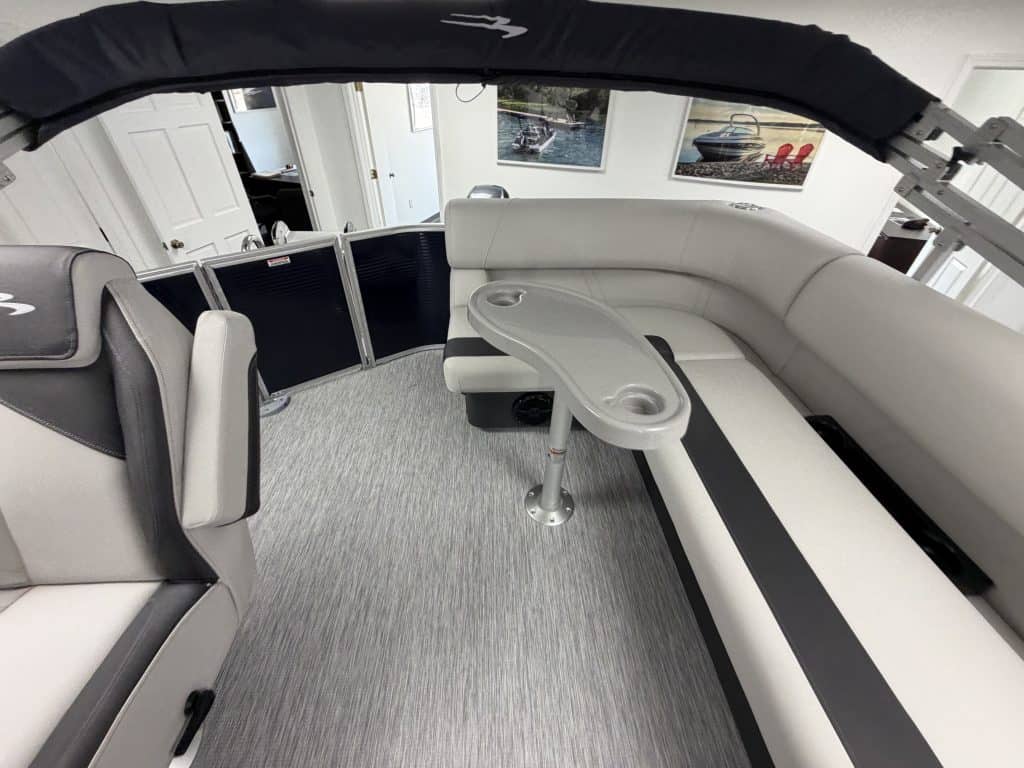 Luxury pontoon boat interior with seating and table at Hall's Sport Center.