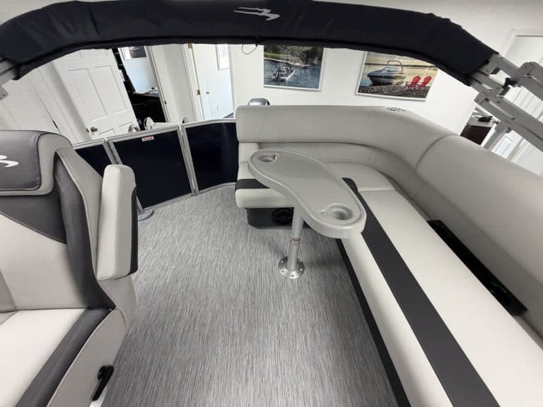 Luxury pontoon boat interior with seating and table at Hall's Sport Center.