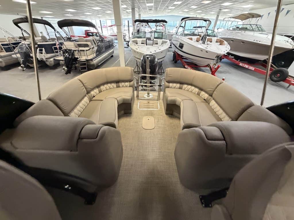 Interior view of a Bennington 25QXFBWA pontoon boat with seating and steering area.