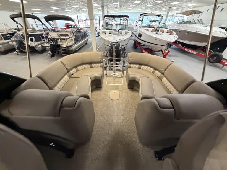 Interior view of a Bennington 25QXFBWA pontoon boat with seating and steering area.