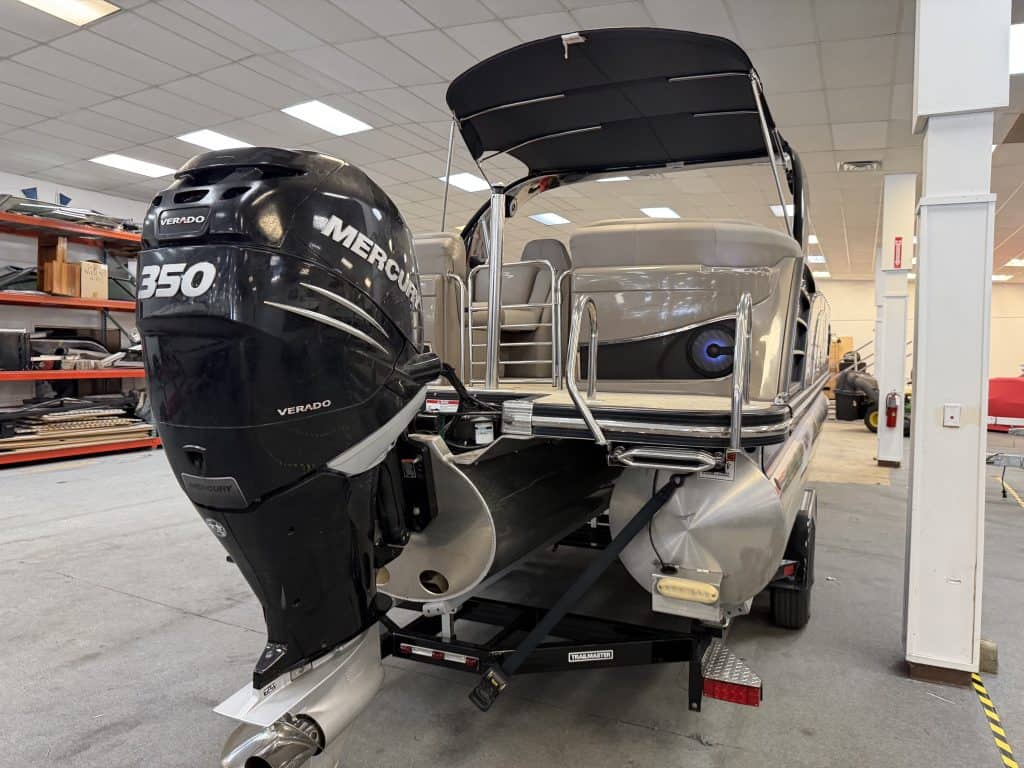 Bennington pontoon boat with Mercury 350 Verado engine inside showroom.
