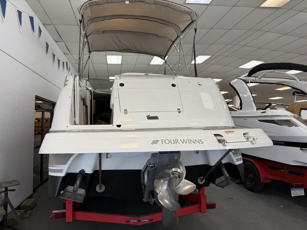 White Four Winns 268 VISTA boat with outboard motor on display.