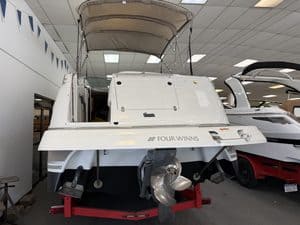White Four Winns 268 VISTA boat with outboard motor on display.