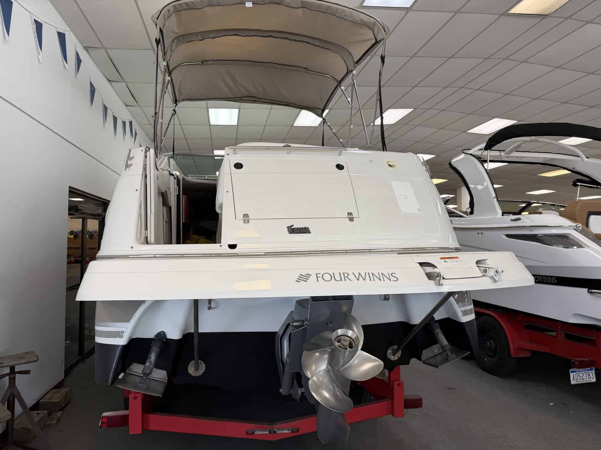 White Four Winns 268 VISTA boat with outboard motor on display.
