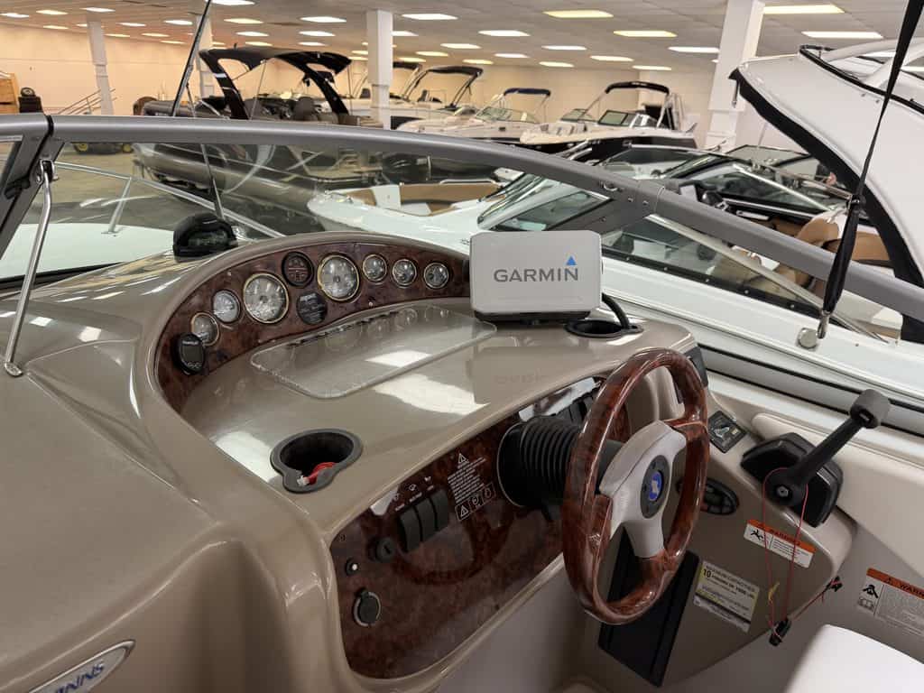 Boat dashboard with Garmin GPS and steering wheel in showroom.