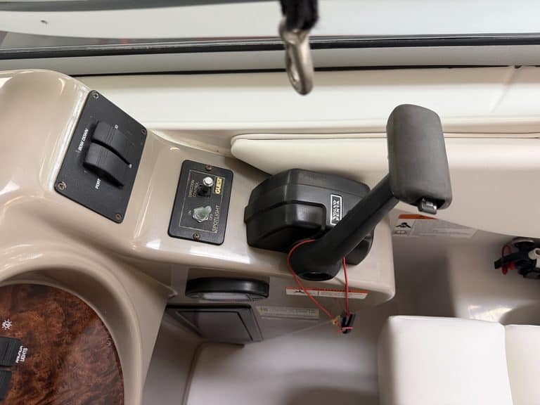 Close-up of boat control console with steering and electronic controls.