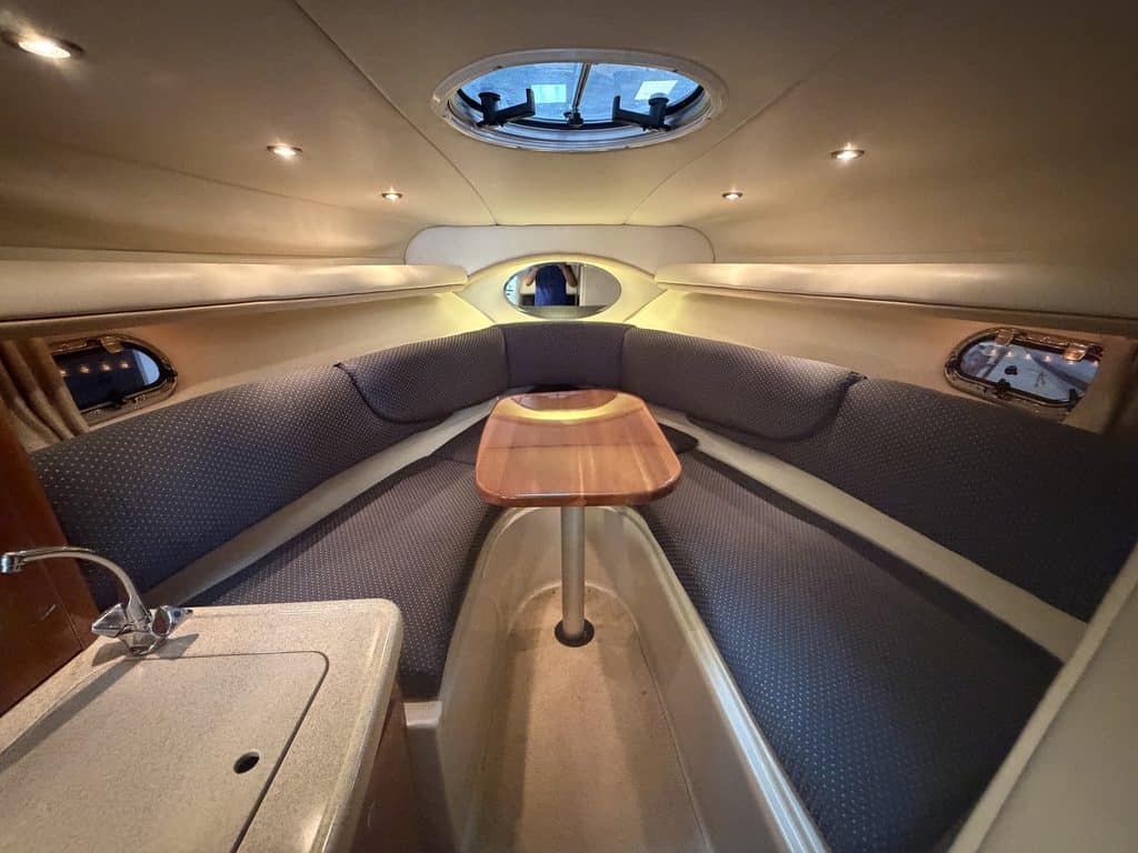 Interior of a 2004 Four Winns 268 VISTA boat with seating and a small table.