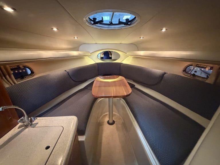 Interior of a 2004 Four Winns 268 VISTA boat with seating and a small table.