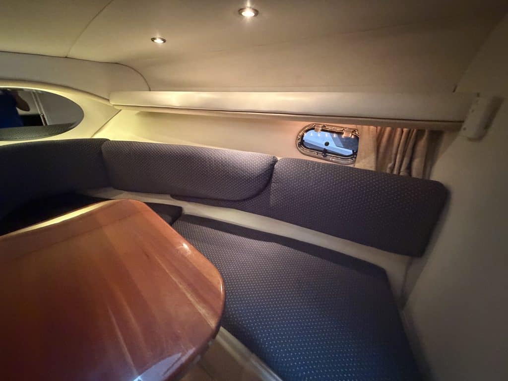 Boat interior with seating and small window at Hall's Sport Center.