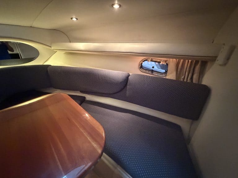Boat interior with seating and small window at Hall's Sport Center.