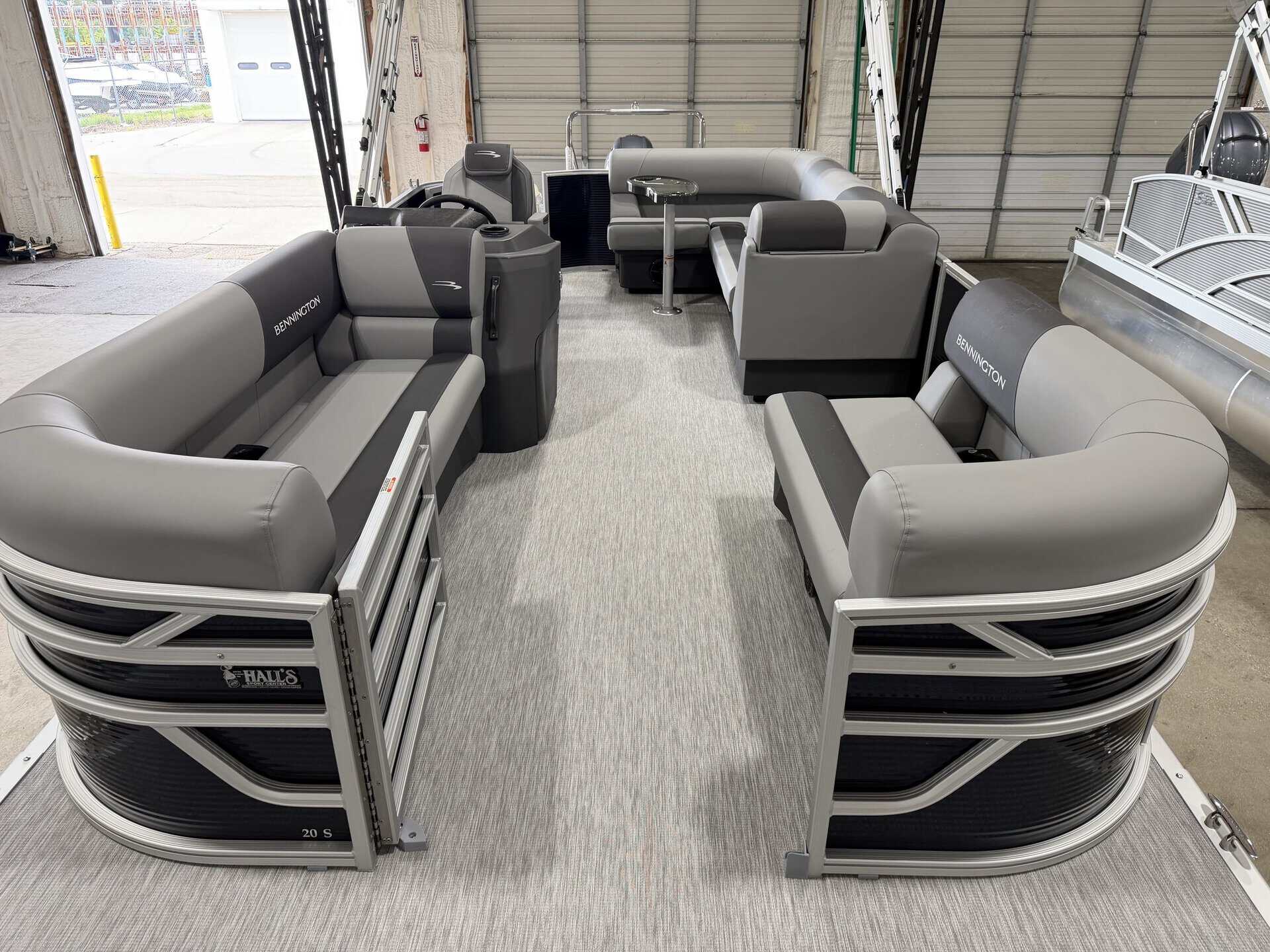 Boat seating area with multiple gray and black cushioned seats at Hall's Sport Center.