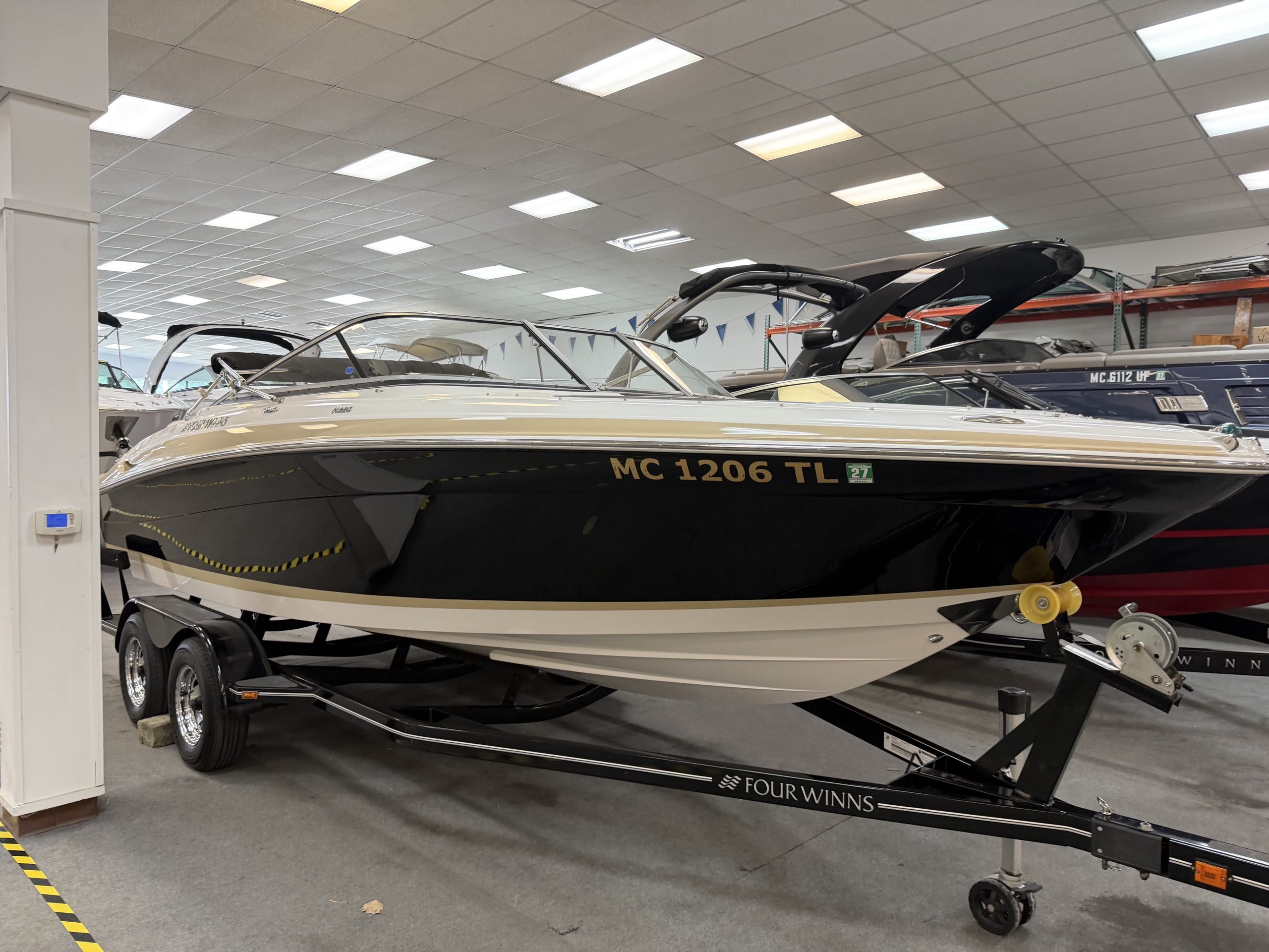 Four Winns 220 Horizon boat on trailer in showroom.
