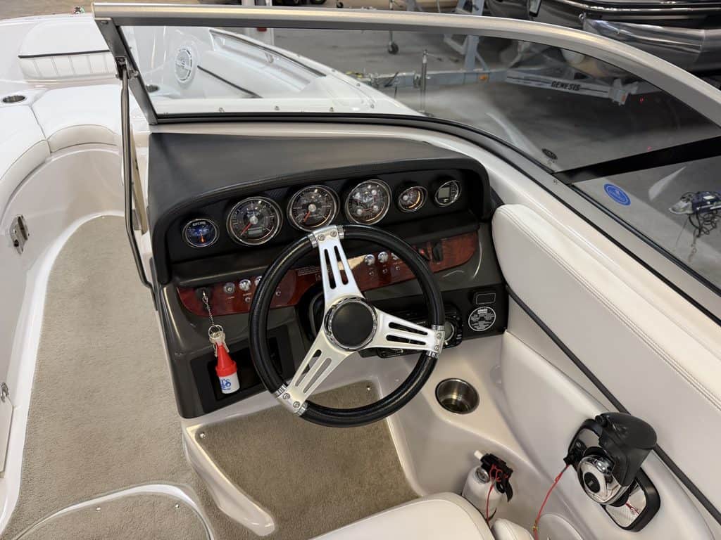 Boat dashboard with gauges and steering wheel in a Four Winns 220 Horizon.