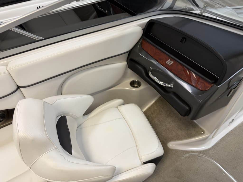 Boat cockpit interior with white seating and dashboard details.