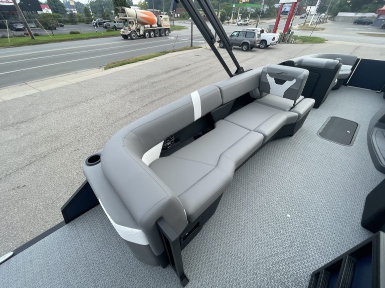 Comfortable boat seating with gray cushions and safety railings.