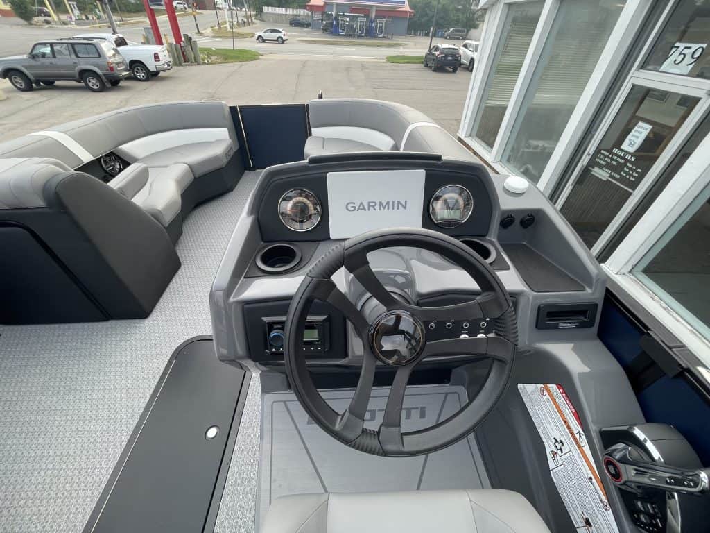 Boat dashboard with Garmin navigation system and steering wheel.