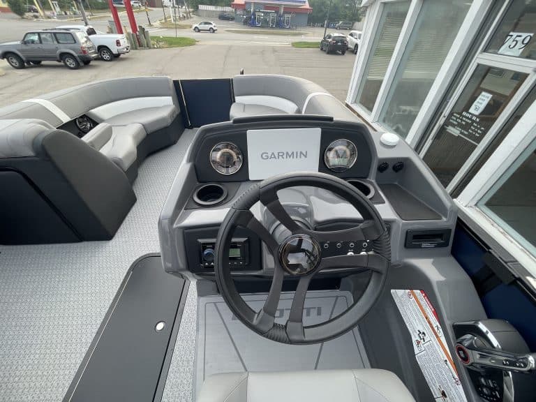 Boat dashboard with Garmin navigation system and steering wheel.