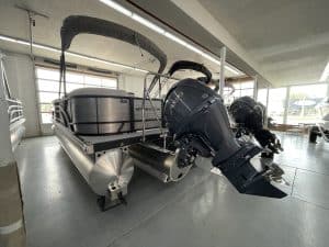 Bennington 22 S1SR pontoon boat with dual outboard motors inside showroom.
