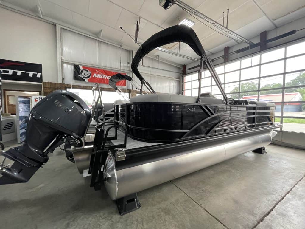 Bennington 22 S1SR pontoon boat inside showroom with outboard motor.