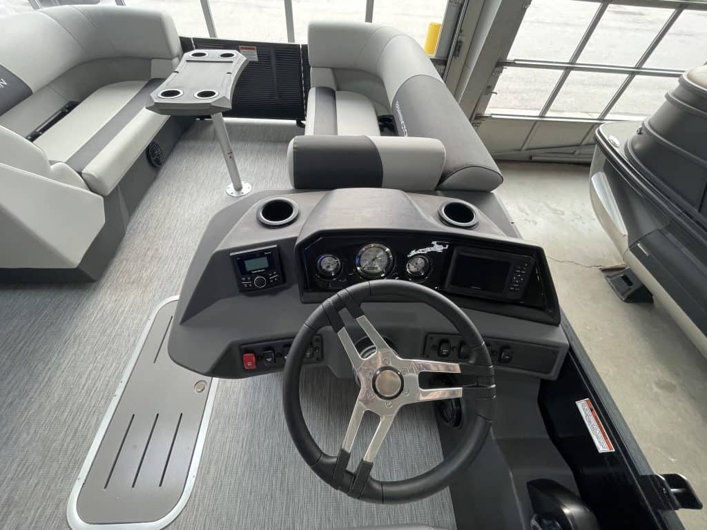Close-up of the dashboard and steering wheel of a Bennington 22 S1SR pontoon boat.