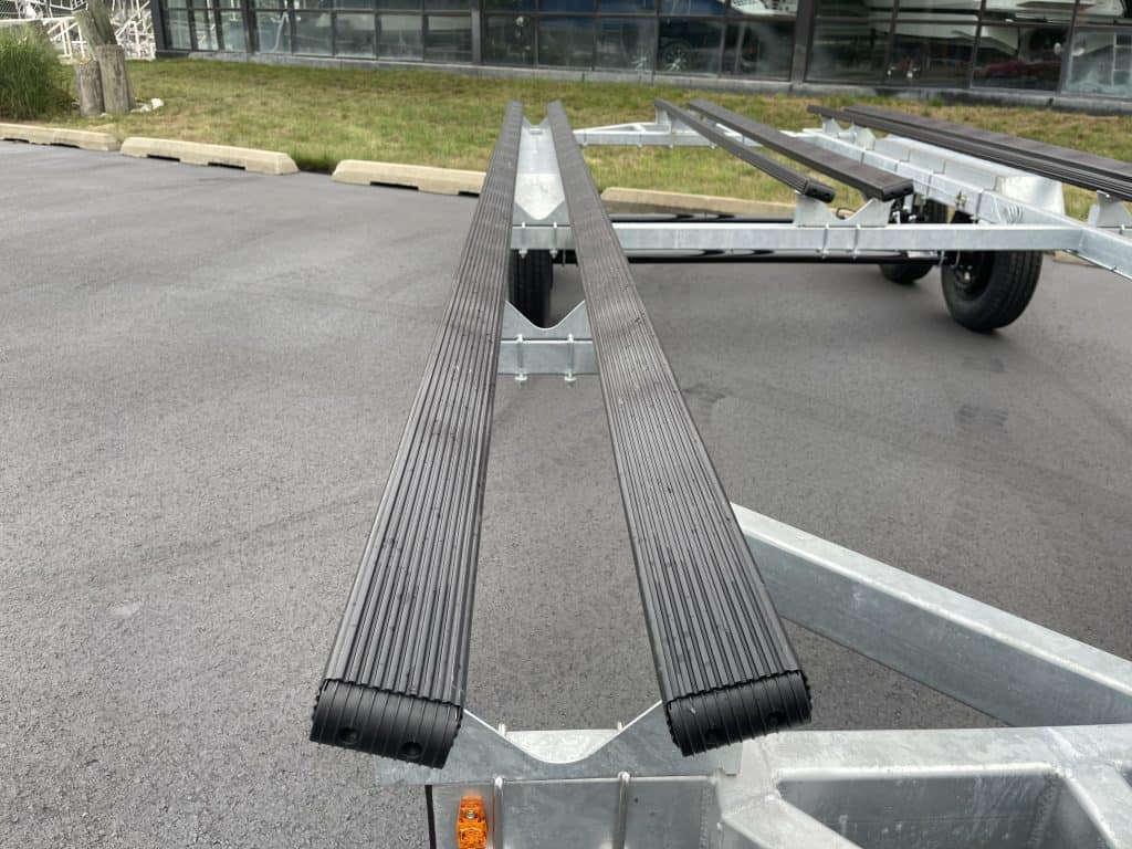 Boat trailer with black rollers at Hall's Sport Center parking lot.